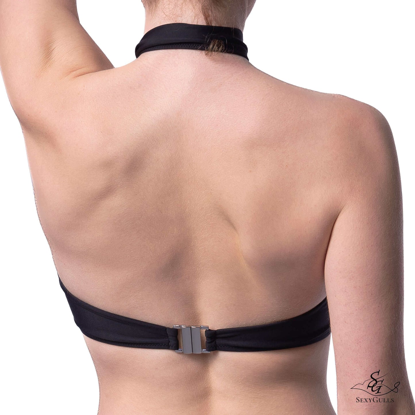 Back view of a woman wearing a black bikini top featuring metallic clasps and behind the neck tie