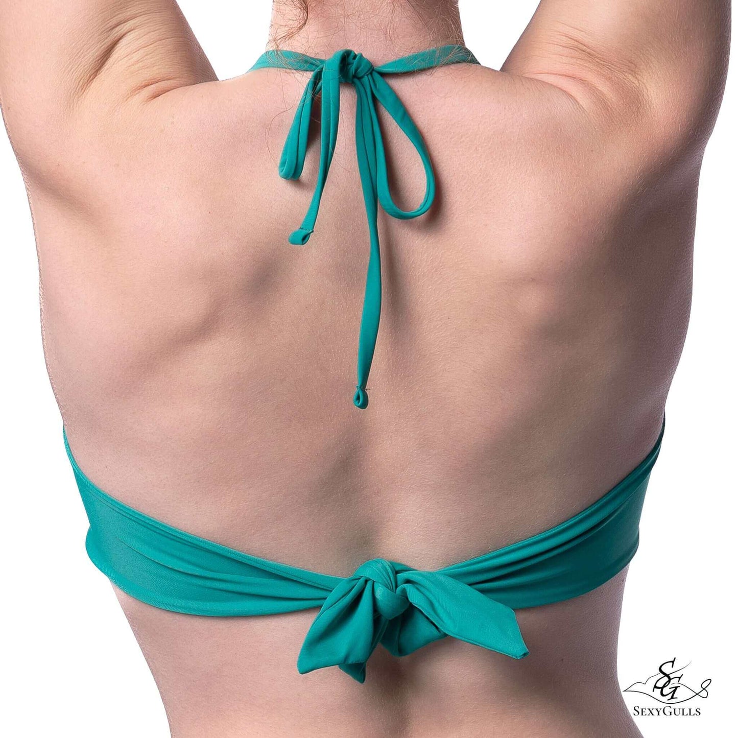 A woman wearing a green tie back bandeau bikini top featuring removable behind the neck tie