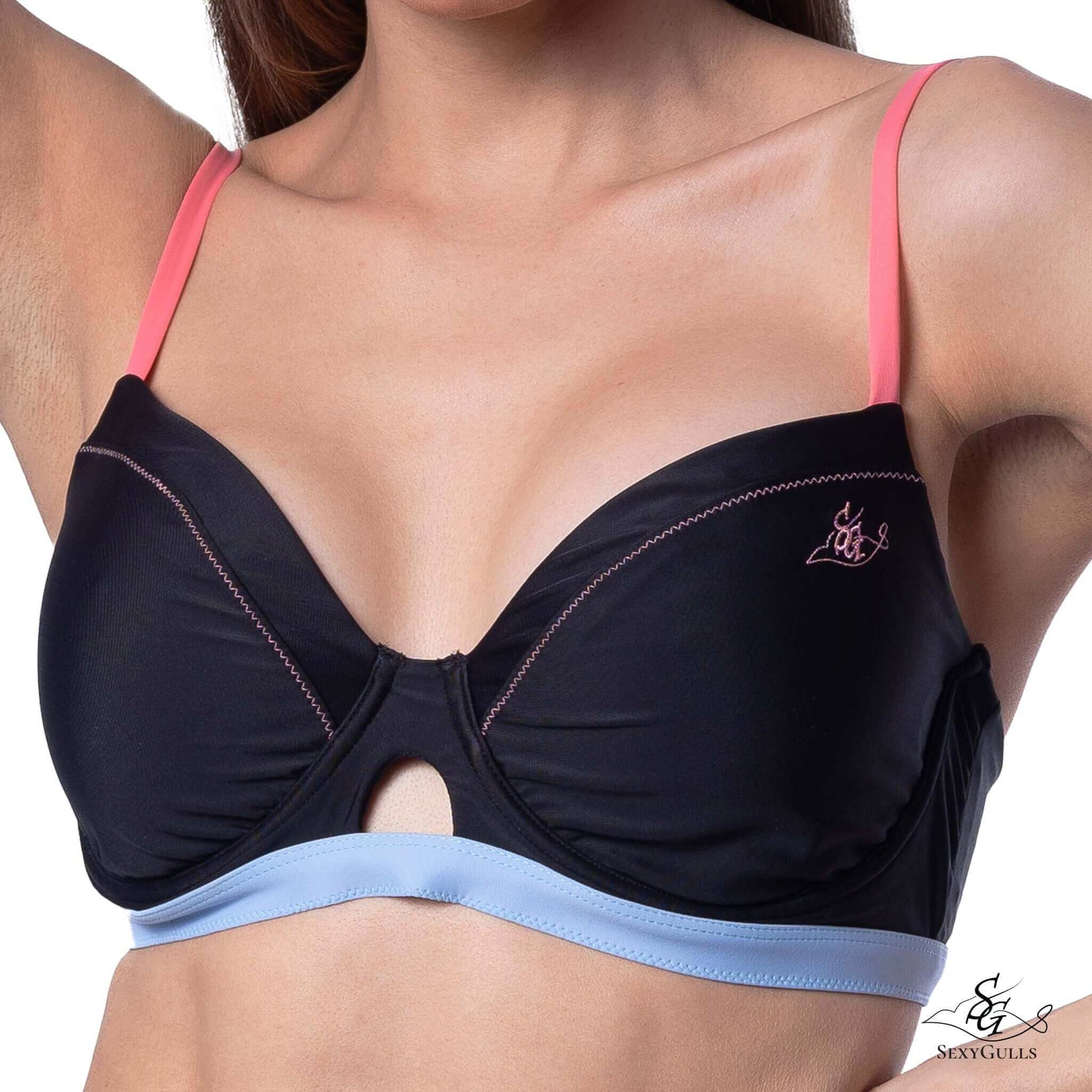 Zoomed in front view for black bikini top with pink shoulder straps and blue under bust band featuring cut-out design